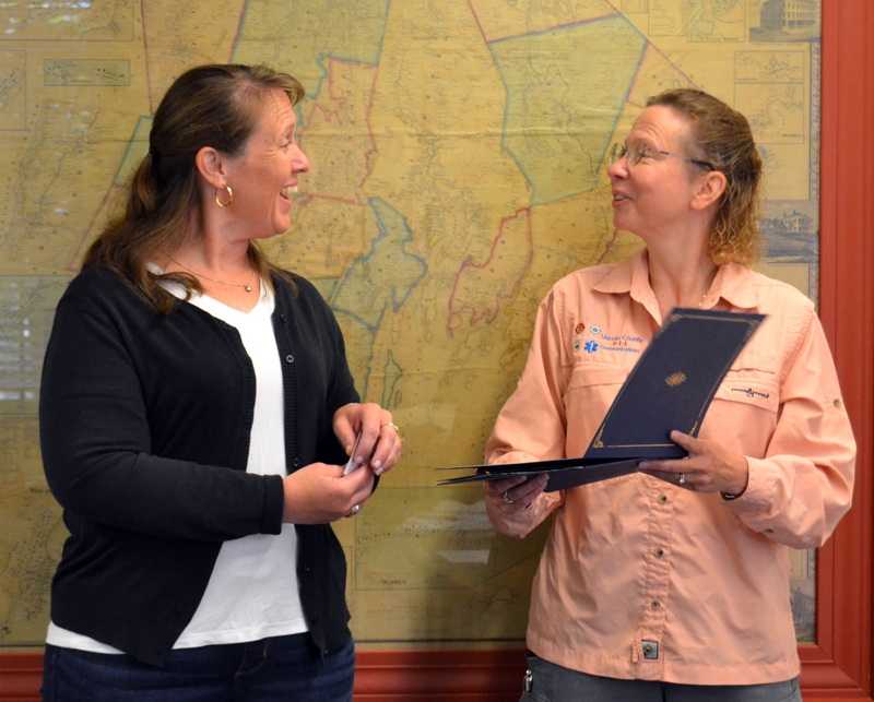 Lincoln County Communications Director Tara Doe (right) presents dispatcher Anita Sprague with a Stork Award at the Lincoln County Board of Commissioners meeting on Tuesday, Aug. 16. On June 13, Sprague successfully helped deliver a baby girl by telephone before emergency medical services arrived on scene. (Charlotte Boynton photo)