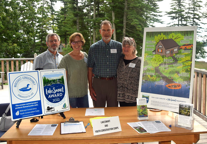 Left to right Peter Gabbe, Carolyn Gabbe, Brent Douglass, and Carter Douglass pose at the LakeSmart table during the first ever State of Damariscotta Lake held at Wavus Camp Grounds on Tuesday, Aug. 23. LakeSmart is an education and outreach program that works with lakefront property owners to help manage their property to create a safer environment for the lake. (Alec Welsh photo)
