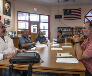Nobleboro Central School Principal Adam Bullard (right) listens to AOS 93 Business Manager Peter Nielsen (left) while NCS committee members Matt Benner, Angela White, and AOS 93 Superintendent Lynsey Johnston review documents prior to a meeting in Nobleboro on Monday, Aug. 8. (Bisi Cameron Yee photo)
