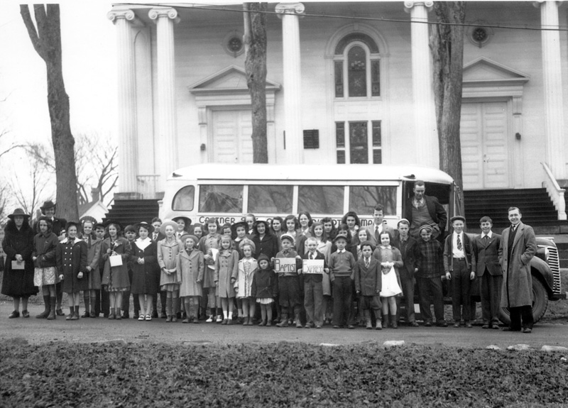 This photo shows Philip R. Hall in the doorway of a bus, Rev. Henderson at the far right, and Mrs. Henderson at the far left, at the rear of the bus. Years later Marjorie and I used to write and talk with Rev. Henderson and I asked him about the photo and I sent it to him and he told us how Mr. Philip R. Hall was so much fun to be around and how he enjoyed the Sunday school children each Sunday. (Photo courtesy Calvin Dodge)