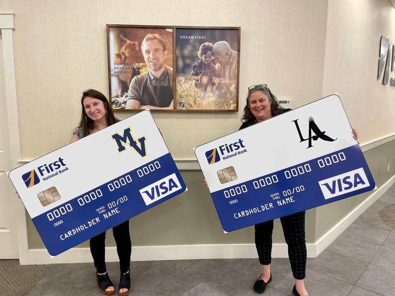 First National Banks Kelsey Briggs and Shannon Young celebrate the launch of the bank's new Spirit Cards. (Photo courtesy First National Bank)
