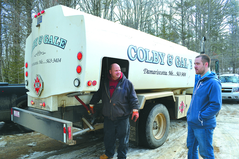 Donnie Leeman (left) prepares to fill a tank in Nobleboro as Colby & Gale Inc. President Matt Poole looks on. Leeman delivered propane for the oil company for the last 10 years. (Maia Zewert photo, LCN file)