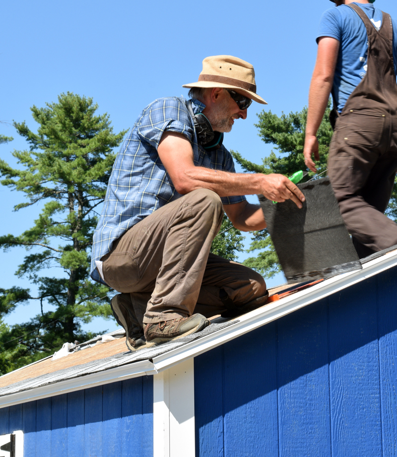 Jesse Ferreira, owner of Damariscotta's Jesse Sheds, installs roofing on a shed built on site in Jefferson on Aug. 4. (Evan Houk photo)
