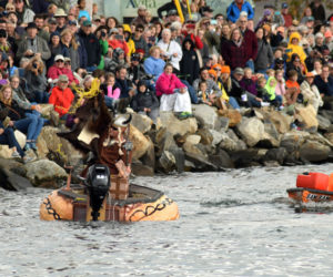 Russell Orms, of Austin, Texas, holds up the "gnome gold" he retrieved from a floating treasure chest as Buzz Pinkham looks on during the 13th annual Damariscotta Pumpkinfest Regatta on Oct. 14, 2019. The Twin Villages is holding the first parade and regatta since 2019 and traffic patterns will be altered in town. (Evan Houk photo, LCN flie)