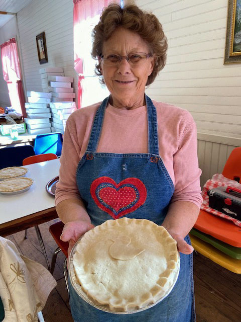 Judy Maldovan, president and treasurer of the Kings Mills Union Hall Association, holds a chicken pie ready for the oven at the 2021 event in Whitefield. (Photo courtesy Lucy Martin)