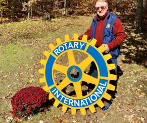 Damariscotta-Newcastle Rotarian Wilton Jones, of Newcastle, shows what could be a 98-year-old sign made for the local club by his grandfather, Wallace Wilton Chadwick. (Photo courtesy Lorraine Faherty)