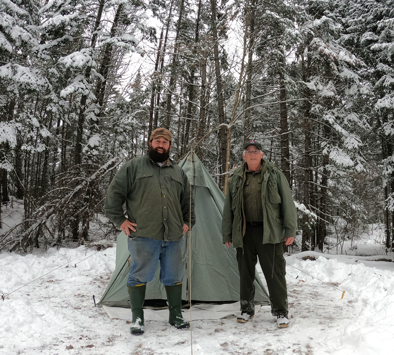 Jefferson men Joe Holland (left) and Donnie Johnston stand in front of Johnston's old time camping equipment on a winter camping trip last winter. (Photo courtesy Joe Holland)