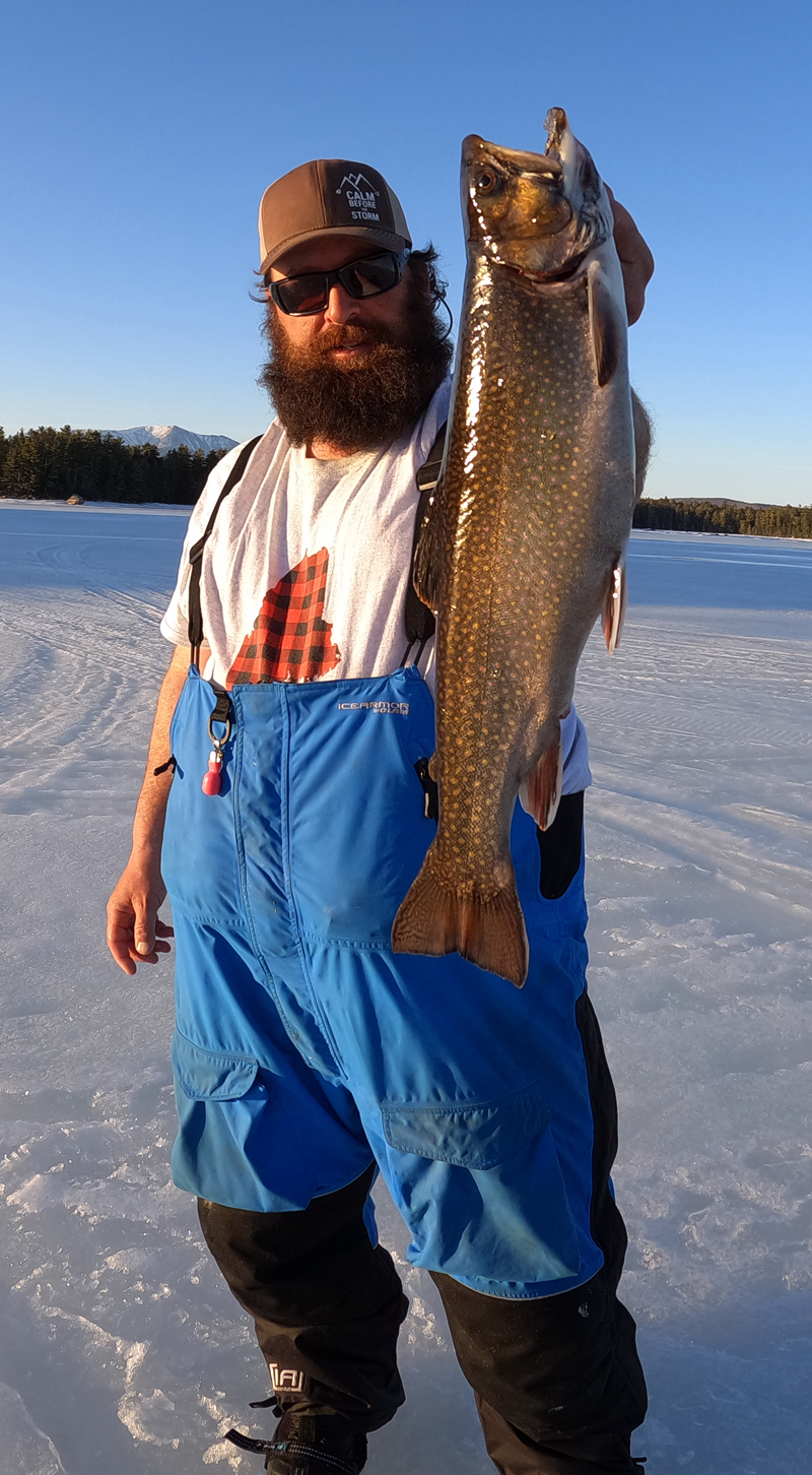 Joe Holland holds up a large lake trout, caught on a winter camping trip. (Photo courtesy Joe Holland)