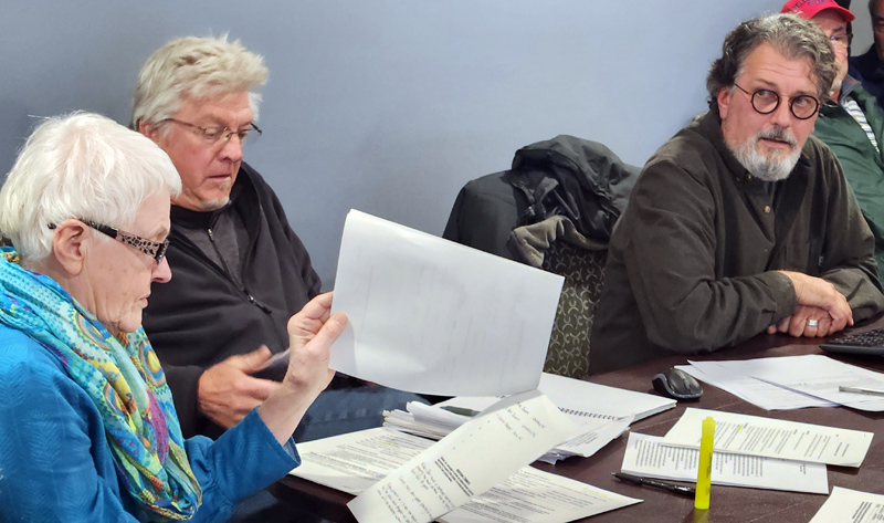 Members of the Alna Select Board, Linda Kristan (left), Charlie Culberston (middle), and Ed Pentaleri review bid proposals for snowplowing services during a special board meeting at the town office Tuesday, Nov. 22. (Alec Welsh photo)