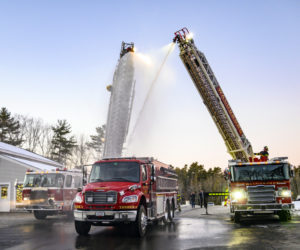 Damariscotta and Waldoboro ladder trucks perform a wetdown ceremony to welcome Bremen's new fire truck into service in Damariscotta on Tuesday, Dec. 20. The tradition dates back to the late 1800s when firefighters washed the horses and firefighting apparatus after a fire. (Bisi Cameron Yee photo)