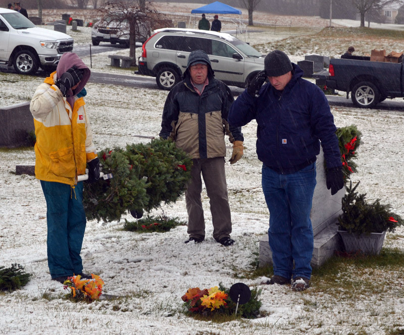 From left: Jim Hazel, David Tonry, and Chad Dietrick pay their respects after placing a wreath on a veterans grave in Hillside Cemetery in Damariscotta on Saturday, Dec. 17. Participating in the first year of a collaborative involving six local Masonic lodges and the Damariscotta-Newcastle Lions Club, volunteers placed a Christmas wreath on all 198 veterans graves in the cemetery. (Sherwood Olin photo)
