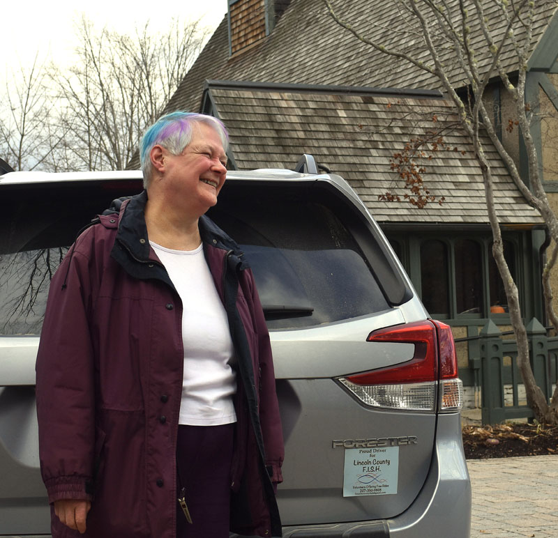 Edie Vaughn stands outside St. Andrew's Episcopal Church in Newcastle with her car magnet that points out she is a "Proud Driver for Lincoln County FISH," or Friends in Service Helping, a mission of the church. She led the founding of the volunteer service offering rides to Lincoln County residents in 2015 and considers it one of the two proudest accomplishments in her life. (Elizabeth Walztoni photo)
