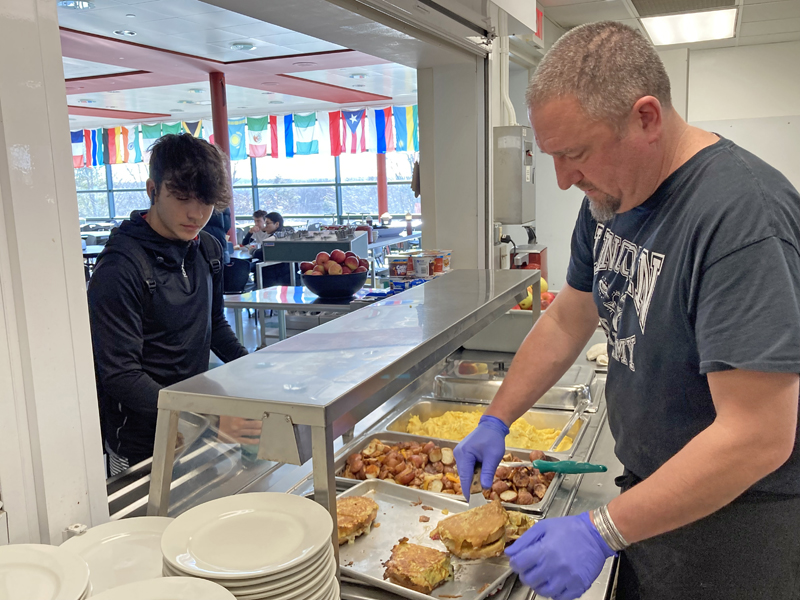 Chef Chad McKernan (right) serves stuffed French toast to a residential Lincoln Academy student during brunch on Sunday, Dec. 4. (Maia Zewert photo)