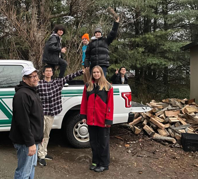Newcastle firefighter Jake Abbot and a group of Lincoln Academy students load up a truck with firewood before making an emergency delivery to a Newcastle resident who is participating in the Community Housing Improvement Programs annual Home Heating Assistance Program. (Courtesy photo)