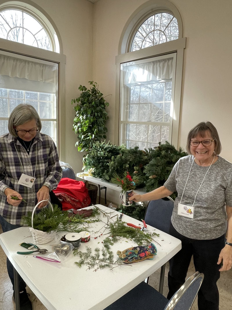 Bonni Hamilton and Sheila Scott make holiday baskets at the Garden Club of Wiscasset's December meeting. (Photo courtesy Jan Flowers)