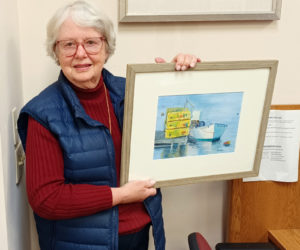 Kay Sawyer Hannah holds up one of her paintings at the Bristol Area Library (Photo courtesy Bristol Area Library)