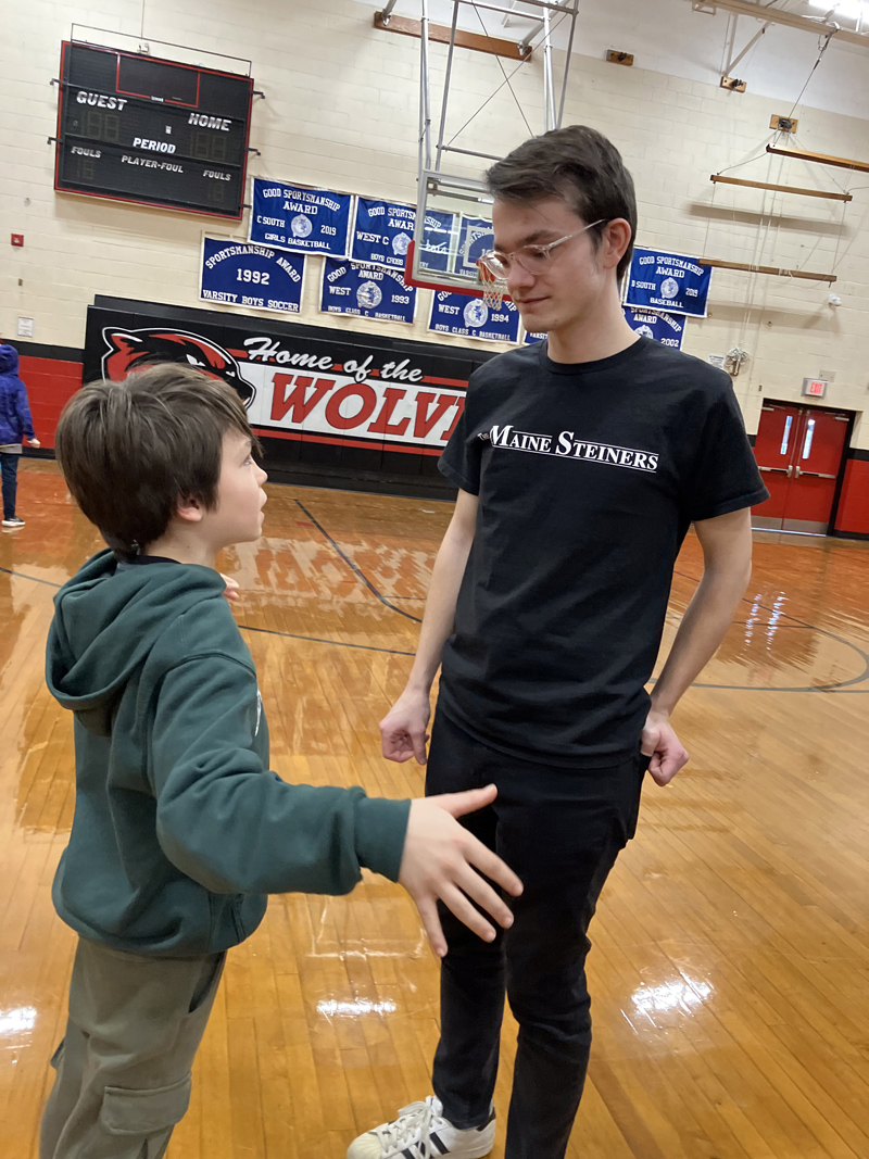 Wiscasset student Everett Oakes chats with The Maine Steiners' Music Director Isaiah Grace during a meet and greet before the UMaine a cappella group performed in the Wiscasset Middle High School gymnasium Tuesday, Jan. 10. (Photo courtesy Becky Hallowell)
