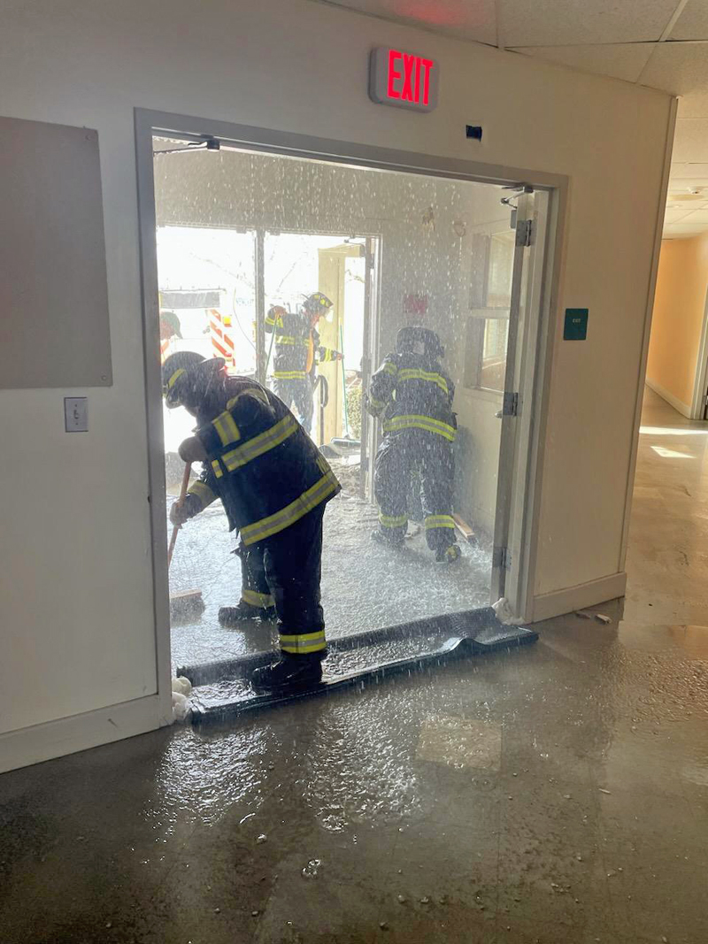 A firefighter cleans up the mess after a water line burst in the Lincoln Academy's Hall House over the weekened. The damage forced the school to close for two days this week. (Photo courtesy Lincoln Academy)