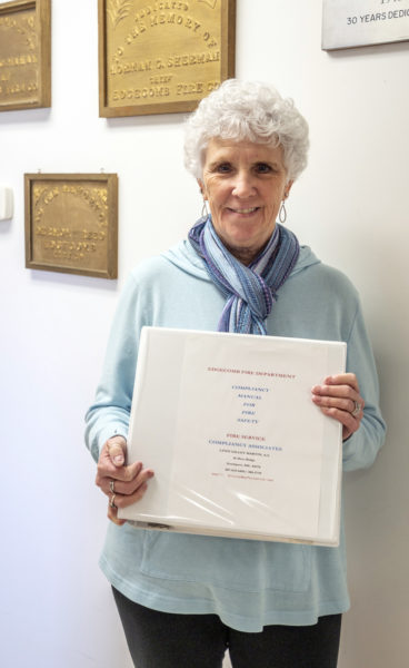 Lynn Martin poses with the manual she created for the Edgecomb Fire Department on Monday, April 10. Consulting with fire departments on safety issues has become a passion for Martin, whose previous career was primarily in the medical field. (Bisi Cameron Yee photo)