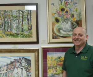 Mike Nussbaum, owner of Salt Bay Framers, stands by the artwork of Gwendolyn Evans at his new gallery space. Six local artists have their work on display currently, and the space provides room for eight more. (Elizabeth Walztoni photo)