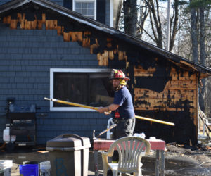 A firefighter works on the scene of a garage fire in Jefferson on Thursday, April 13. The owner of the home knocked down the fire with a garden hose before firefighters arrived. (Elizabeth Walztoni photo)