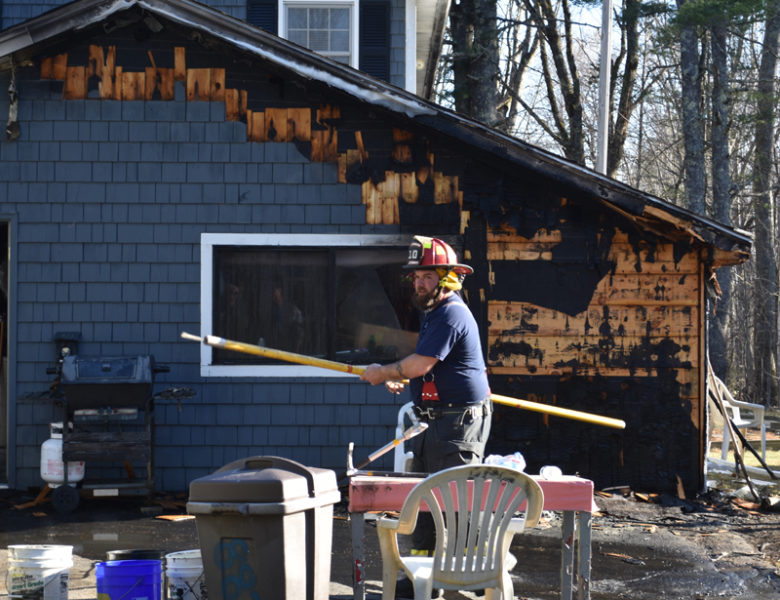 A firefighter works on the scene of a garage fire in Jefferson on Thursday, April 13. The owner of the home knocked down the fire with a garden hose before firefighters arrived. (Elizabeth Walztoni photo)
