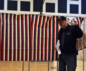 Bob Heinlein emerges from the voting booth at Jefferson's annual town meeting by referendum in the Jefferson Village School gymnasium on Tuesday, April 18. Deputy Town Clerk Brenda Williams said voter turnout was higher than expected Tuesday morning. (Elizabeth Walztoni photo)