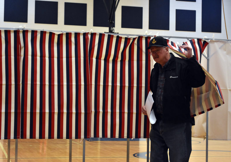 Bob Heinlein emerges from the voting booth at Jefferson's annual town meeting by referendum in the Jefferson Village School gymnasium on Tuesday, April 18. Deputy Town Clerk Brenda Williams said voter turnout was higher than expected Tuesday morning. (Elizabeth Walztoni photo)