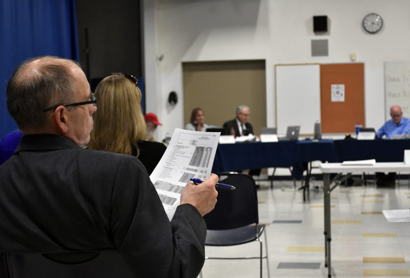 A member of the audience reviews budget documents at a special meeting of the RSU 40 Board of Directors on Thursday, April 13. The budget appearing before voters in June is $480,000 less than initially proposed. (Elizabeth Walztoni photo)