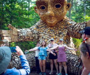 Visitors to Coastal Maine Botanical Gardens pose with one of the five trolls on the grounds. (Photo courtesy Coastal Maine Botanical Gardens)