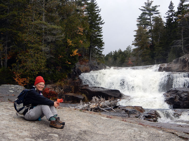 Retired lawyer and current Alna Planning Board member Cathy Johnson sits near a waterfall, enjoying the Maine outdoors. (Courtesy photo)