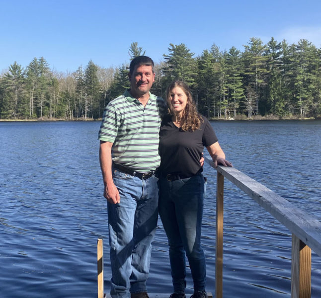 Joel Pitcher and Sherri Simmons, owners of Tiny Cabins of Maine, stand in front of Given's Pond, excited for the future of their new Whitefield-based business. (Meira Bienstock photo)