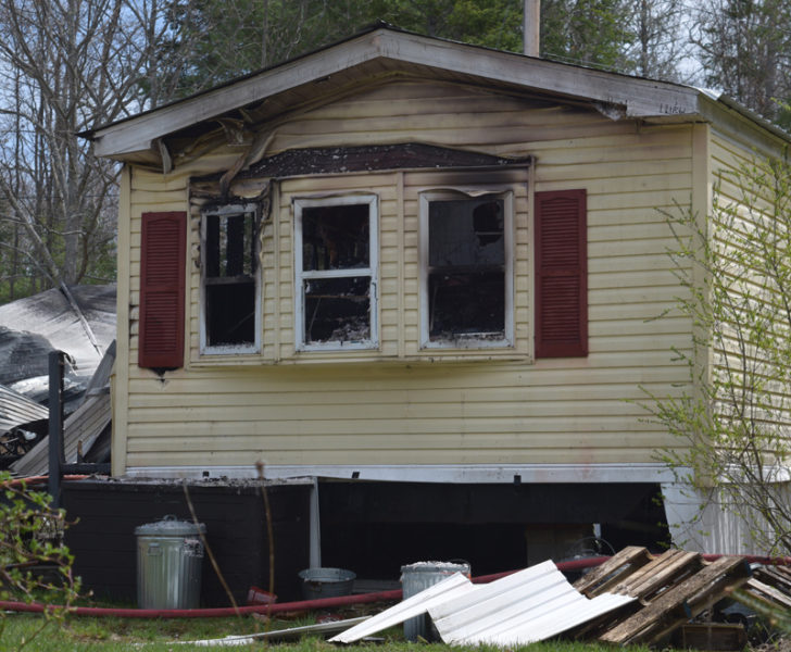 Fire damage shows in the bay windows at one end of a single-wide mobile home owned by Mary and Steve Moulton on Townhouse Road in Whitefield. Whitefield Fire Chief Jesse Barton said a closed bedroom door helped contain the fire Saturday, April 29. (Sherwood Olin photo)