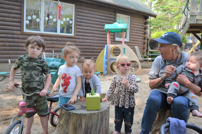 Kids at Harbor Day Care in Bristol gather around a speaker playing sing-along songs on Friday, June 16. Laurie Mahan, founder of the 35-year-old daycare, encourages them to sing along. From left: Casen Weatherbee, 4; Gwen Gomez, 3; Gwen Grinnell, 2; Ireland Creamer, 2; Laurie Mahan, and Ellis Creamer. (Johnathan Riley photo)