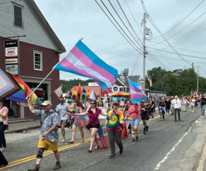 Pride supporters march down Damariscotta's Main Street during the second annual Pride and Unity Walk and Rally on Saturday, June 24. The parade featured participants carrying signs, flying flags, and playing music. (Dylan Burmeister photo)