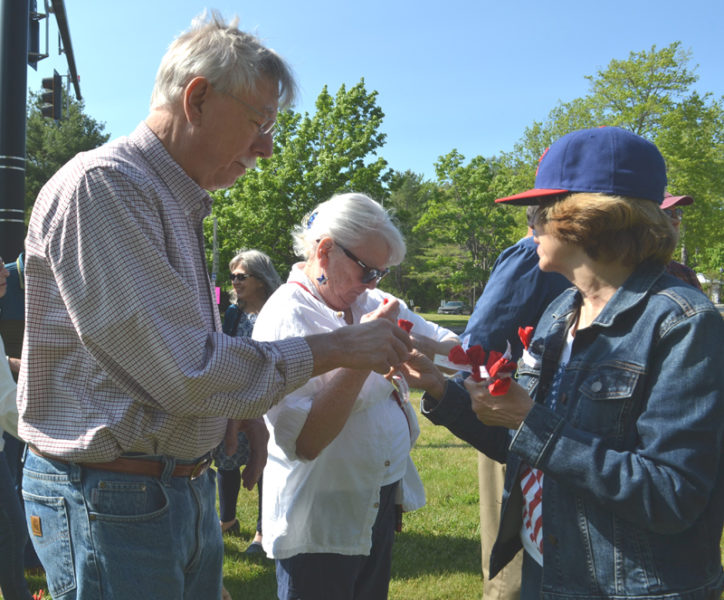 Wiscasset Auxiliary Member Faye Shea, right, distributes poppies to Brian and Linda Adams during Wiscasset's Memorial Day Observance, Monday, May 29. (Charlotte Boynton photo)