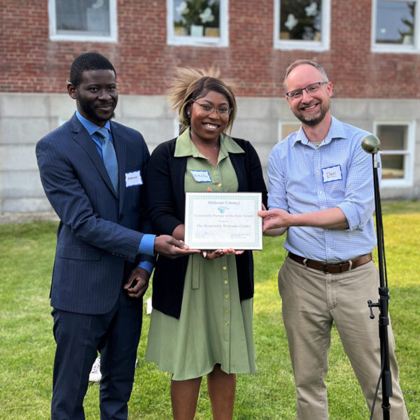 Rodrigue Mwenge and Benedita Kakhuba, of the Brunswick Welcome Center, accept the Community Partner Award from Midcoast Literacy's Executive Director Daniel Burson. (Photo courtesy Bree Candland)