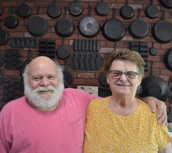 Dorothy "Dot" and Edgar Ouellette, owners and operators of Dot's Bakery in Round Pond, stand in front of their collection of cast iron skillets and baking sheets in their home. After 40 years of running the business, the couple closed Dot's Bakery earlier this month. (Johnathan Riley photo)