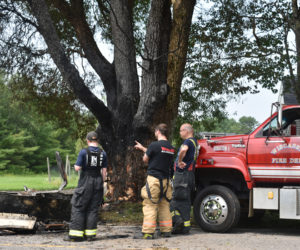 Members of the Wiscasset Fire Department work on the scene of a collision the morning of Wednesday, July 19. A box truck driven by Matthew Smith, 36, crashed into a tree then caught fire. (Elizabeth Walztoni photo)