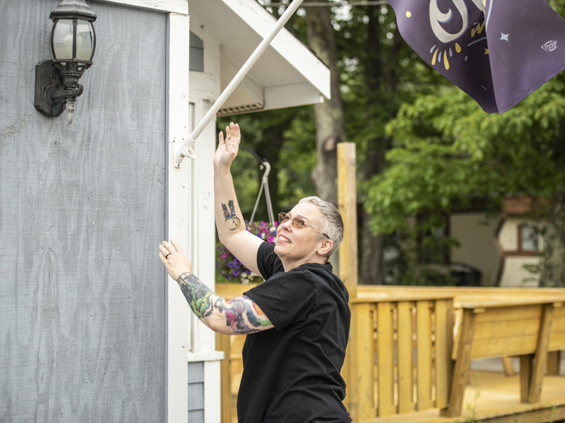 Jodie Roquemore adjusts the open flag outside Jodie's Cafe and Bakery in Wiscasset on Sunday, July 2. The business just celebrated its first anniversary. (Bisi Cameron Yee photo)