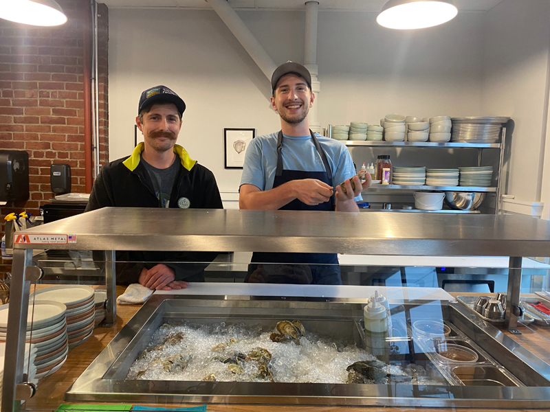 Jolie Rogers Raw Bar co-owners Ryan Jolie (left) and Andy Rogers stand behind the shucking bar in their new location in Wiscasset. The business partners have always had the end goal of opening a brick-and-mortar location. (Frida Hennig photo)