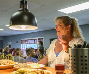 Sherre Faulkingham gathers plates from the pass-through to serve customers at Sherres Kitchen in Wiscasset on Sunday, July 2. Faulkingham is the owner, manager, and full-time server at the new breakfast spot on Route 27. (Bisi Cameron Yee photo)