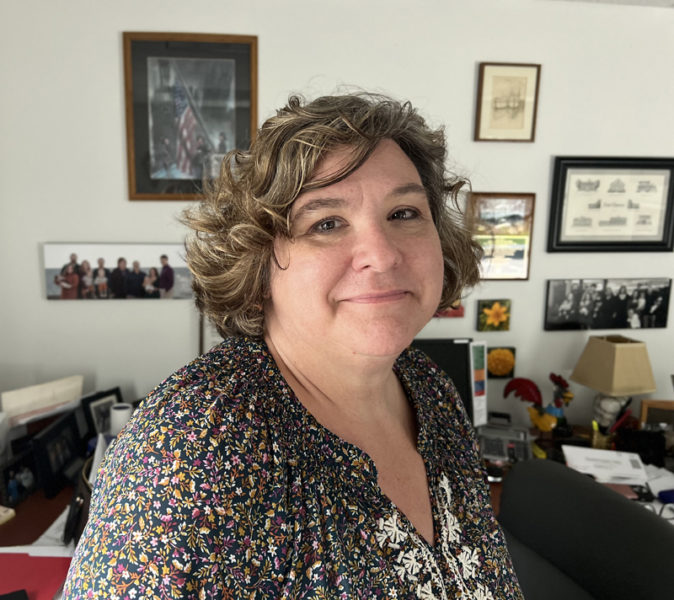 Waldoboro Town Manager Julie Keizer in her office in the town hall. Out of frame is a metal basket on her desk of wooden quahogs that have been burnt and burnished to look like they have just been pulled from the mud.