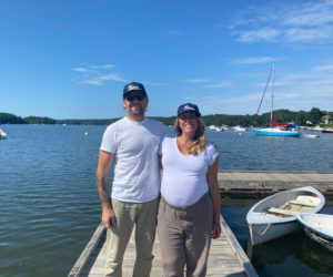 Meredith Spratt and Logan Livingston stand in front of the Damariscotta River. The couple is offering river tours and day charters with their business, Sandpiper Maine Excursions, through which guests are able to learn about the river, enjoy the views, and go swimming. (Frida Hennig photo)