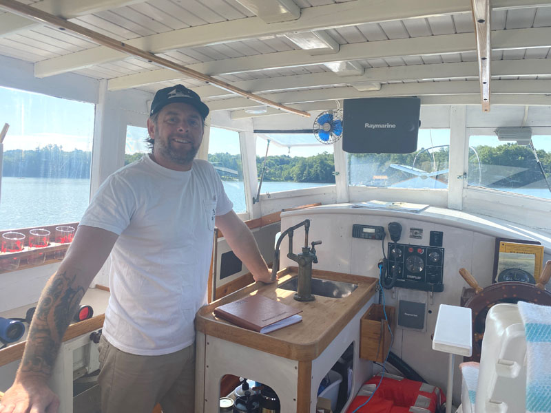 Logan Livingston stands in the wheelhouse of Sandpiper, the 32-foot lobster cruiser that he owns with his wife, Meredith Spratt. While Spratt captains the boat, Livingston does maintenance and engineering. (Frida Hennig photo)