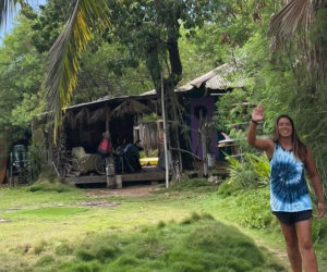 Emma Lazzari waves in front of her house in Lahaina, Hawaii in a photo taken before the Aug. 8 wildfires. Lazzari said her house was near popular surf spots and friends would often park there to get access to the beach. (Photo courtesy Emma Lazzari)