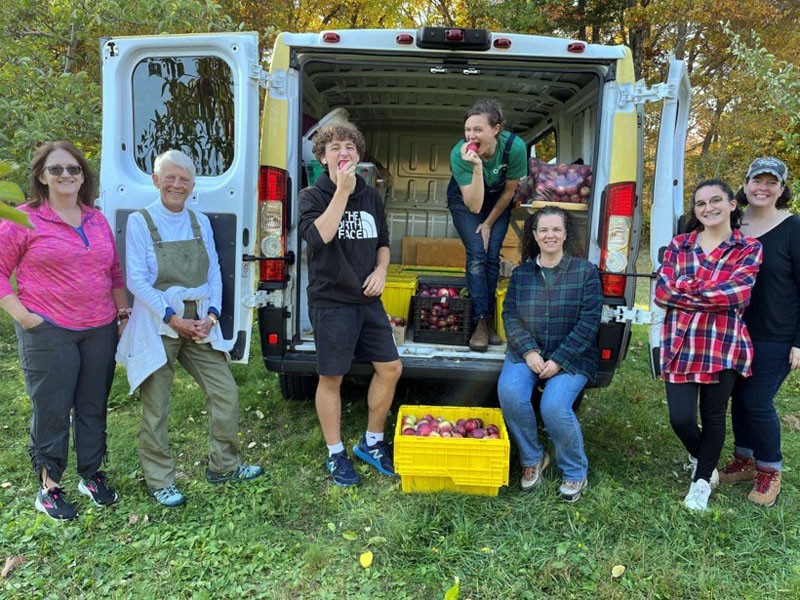 Jess Breithaupt picks apples with community helpers. (Photo courtesy Healthy Lincoln County)