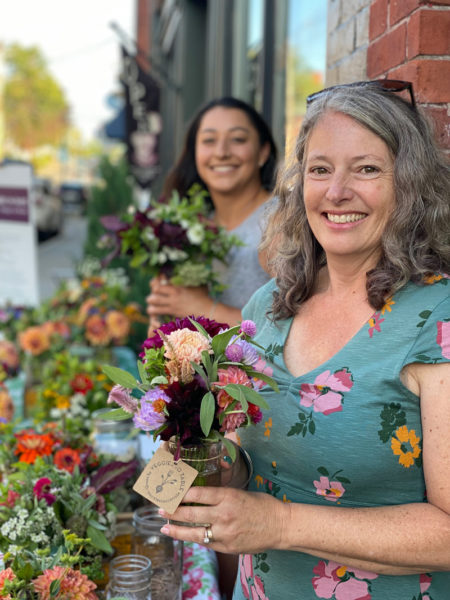 Veggies to Table volunteers Erica Davis (right) and Bonnie Barber hold flowers harvested from the farm. (Photo courtesy Erica Berman)