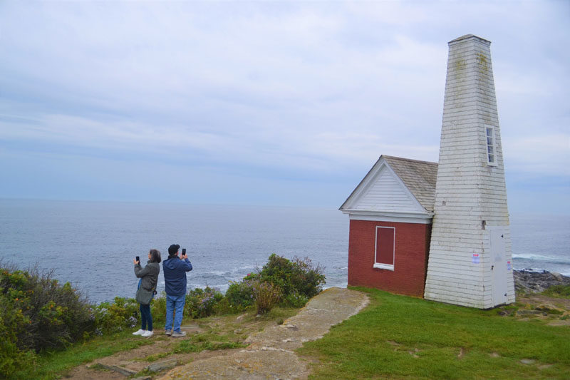Tourists capture the scenery at Pemaquid Point Lighthouse Park with their cellphones on an overcast morning in September. (Johnathan Riley photo)
