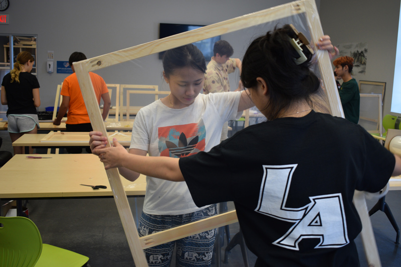 Students in Lincoln Academy's residential program build window inserts as a part of Community Cares Day on Saturday, Sept. 9. This is the fifth year Lincoln Academy has hosted window insert construction at ATEC and the seventh year LAÂ’s residential life program has volunteered with the Community Housing Improvement Project Inc. at the start of the school year. (Zeke Cunningham photo)